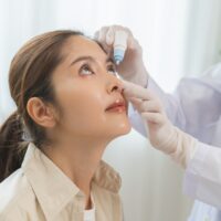 Doctor putting eyedrops in a woman's eyes